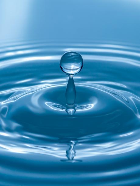 water droplet causing a ripple in blue