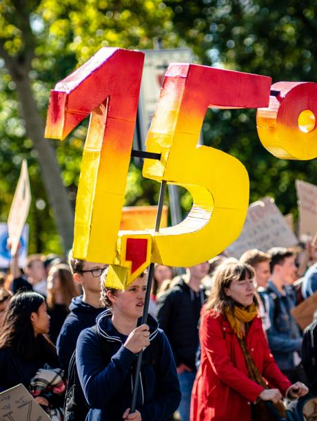 a crowd holding a sign saying 1.5 degrees