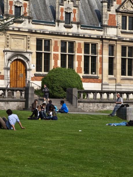 some students lounging in the sun on a campus