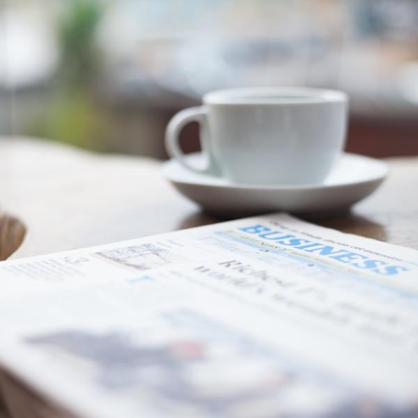 A newspaper and coffee cup