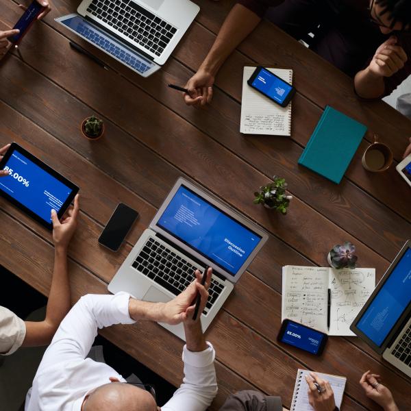 a group of people with laptops at a table viewed from above